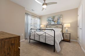 Marysville apartment for rent - A bedroom with a bed, nightstand, and a painting on the wall.