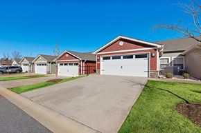 Mauldin apartment for rent - A red house with a white garage door is in front of other houses.