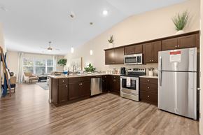 Mauldin apartment for rent - A kitchen with brown cabinets and a stainless steel refrigerator.
