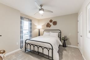 Mauldin apartment for rent - A bedroom with a large bed and a ceiling fan.
