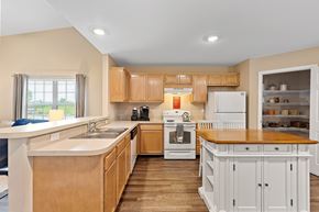 Maumee apartment for rent - A kitchen with wooden cabinets and a white refrigerator.