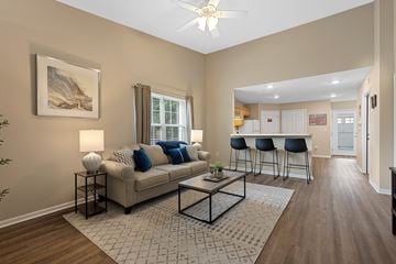 Maumee apartment for rent - A living room with a beige couch, a coffee table, and a painting on the wall.