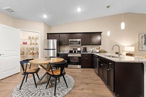 Maumee apartment for rent - A kitchen with a table and chairs in the middle of the room.