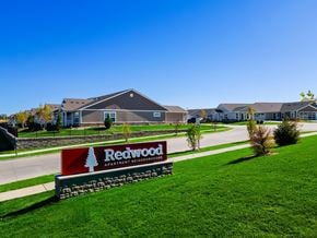 Merrillville apartment for rent - A sign for Redwood Apartment Neighborhood in front of some houses.