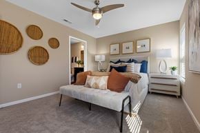 Merrillville apartment for rent - A bedroom with a bed, a ceiling fan, and a nightstand.