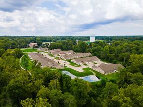 Miami Township apartment for rent - A bird's eye view of a residential area with houses surrounded by trees.