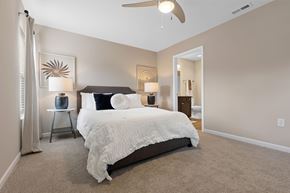 Miami Township apartment for rent - A bedroom with a large bed and a ceiling fan.