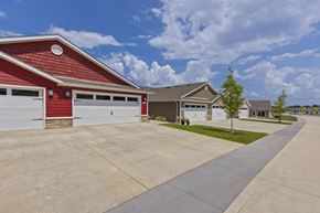 Dayton apartment for rent - A red building with a white garage door is in front of a house.