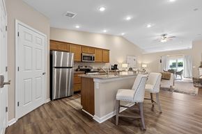 Milford apartment for rent - A kitchen with a refrigerator, microwave, and a counter with two chairs.