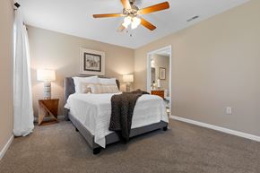 Milford apartment for rent - A bedroom with a bed, a ceiling fan, and a nightstand with a lamp.