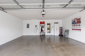 Milford apartment for rent - A spacious room with a concrete floor and white walls, equipped with a charging station and a refrigerator.