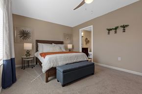 Monroe apartment for rent - A bedroom with a large bed and a bench.