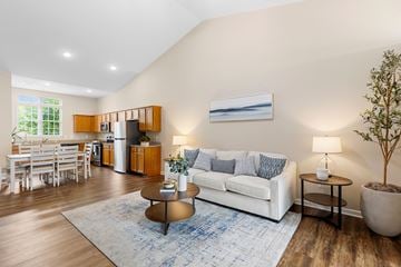 New Albany apartment for rent - A living room with a white couch, a coffee table, and a dining table with chairs.