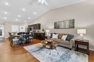 Newark apartment for rent - A living room with a grey couch, a coffee table, and a painting on the wall.