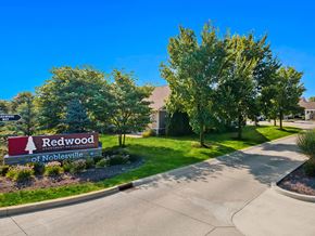 Noblesville apartment for rent - A sign for Redwood of Noblesville is in front of a building.