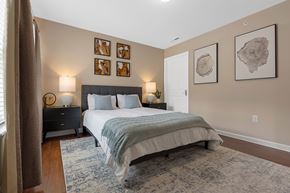 Noblesville apartment for rent - A bedroom with a bed, nightstand, and pictures on the wall.