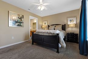 Noblesville apartment for rent - A bedroom with a bed, nightstand, and a ceiling fan.