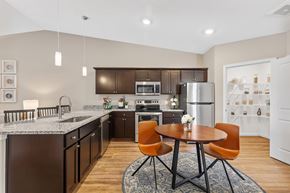 Groveport apartment for rent - A modern kitchen with a table and chairs in the middle.