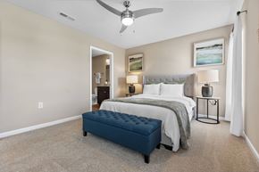 Groveport apartment for rent - A bedroom with a bed, nightstand, and a fan.