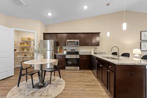 Omaha apartment for rent - A kitchen with brown cabinets and a white fridge.