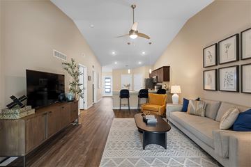 Omaha apartment for rent - A living room with a grey couch and a wooden floor.