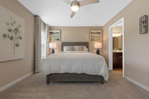 Omaha apartment for rent - A bedroom with a large bed and a ceiling fan.