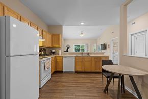 Oregon apartment for rent - A kitchen with a white refrigerator and wooden cabinets.