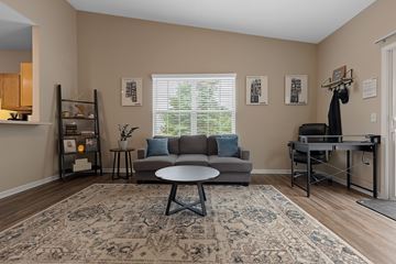 Oregon apartment for rent - A living room with a grey couch, a round table, and a rug with a pattern.