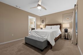 Oswego apartment for rent - A bedroom with a large bed and a ceiling fan.