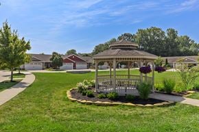 Pataskala apartment for rent - A gazebo is surrounded by a flower bed in a grassy area.