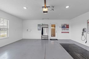 Perrysburg apartment for rent - A spacious room with a door, window, and a wall-mounted hose reel.
