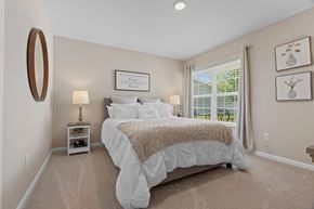 Pickerington apartment for rent - A bedroom with a large bed and a window with blinds.