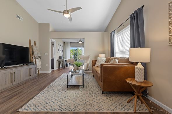 Portage apartment for rent - A living room with a brown couch and a ceiling fan.