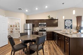 Reynoldsburg apartment for rent - A kitchen with brown cabinets and a table with chairs.