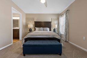 Rochester Hills apartment for rent - A bedroom with a large bed and a ceiling fan.
