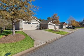 Simpsonville apartment for rent - A residential street with a house and a tree in the foreground.