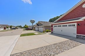 Sugarcreek Township apartment for rent - A red building with a white garage door is in front of a water tower.