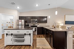 Sugarcreek Township apartment for rent - A modern kitchen with dark brown cabinets and a white island.