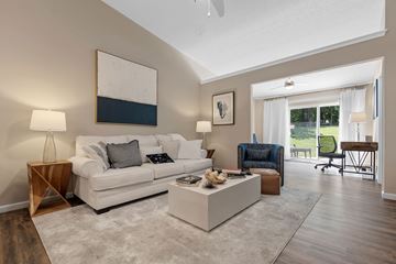 Sugarcreek Township apartment for rent - A living room with a white couch, a coffee table, and a painting on the wall.