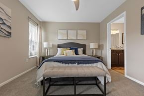 Superior Township apartment for rent - A bedroom with a bed, nightstands, and a ceiling fan.