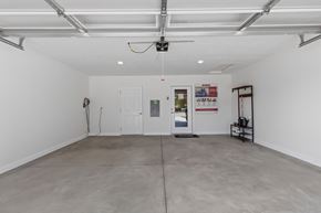 Superior Township apartment for rent - A spacious room with a white ceiling and walls, a grey floor, and a few pieces of furniture.