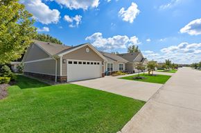 Kalamazoo apartment for rent - A house with a garage is surrounded by a well-kept lawn.