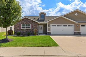 Tipp City apartment for rent - A house with a stone facade and a garage door.