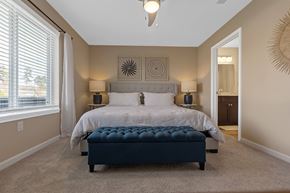 Troutman apartment for rent - A bedroom with a large bed and a bench in front of it.