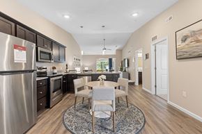 Dayton apartment for rent - A kitchen with a dining table and chairs in the middle of the room.