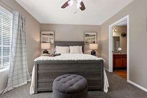 Washington Township apartment for rent - A bedroom with a bed, a ceiling fan, and a window with curtains.