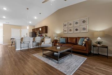 Waukee apartment for rent - A living room with a brown leather couch and a coffee table.