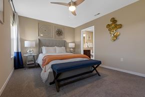Waukee apartment for rent - A bedroom with a large bed and a ceiling fan.