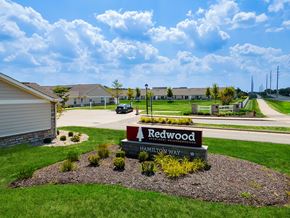 Westfield apartment for rent - A sign for Redwood Estates is in the foreground of a grassy area.