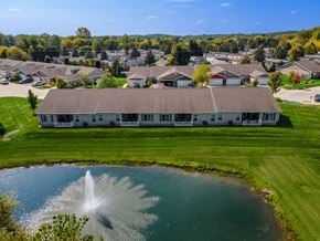 White Lake apartment for rent - A fountain in the middle of a pond in front of a building.